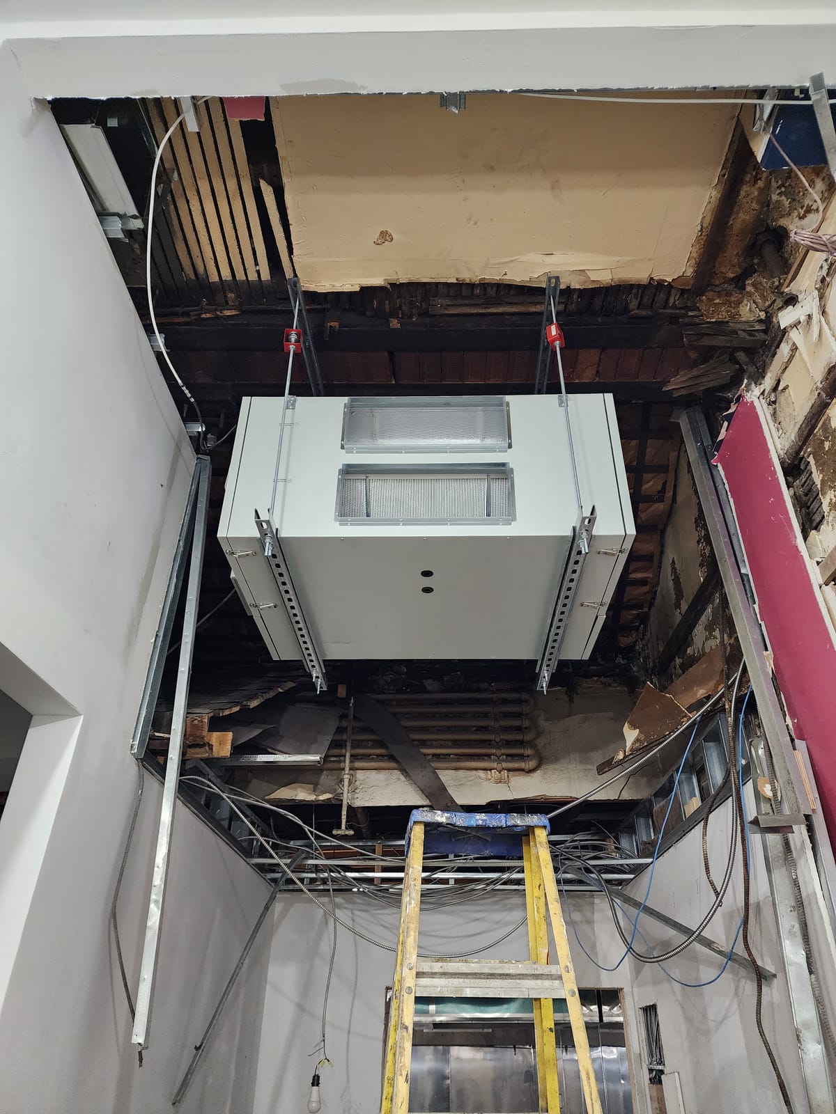 Commercial space with air handler being installed from ceiling