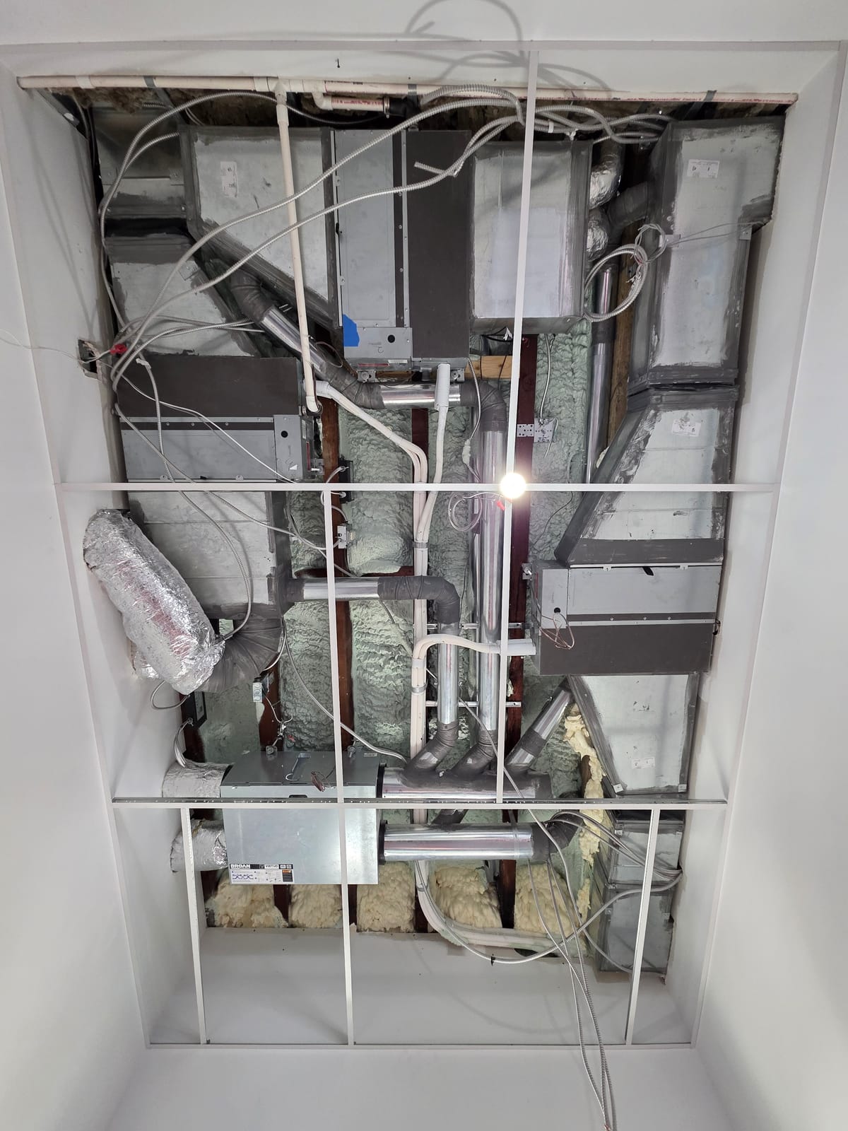 Ceiling opened showing full HVAC system with ducts and insulation